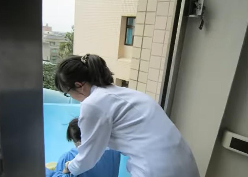 病人由醫護人員抬上逃生滑梯。(影片截圖)