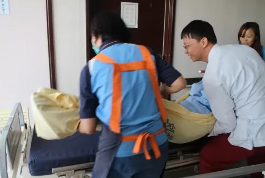 病人由醫護人員抬上逃生滑梯。(影片截圖)