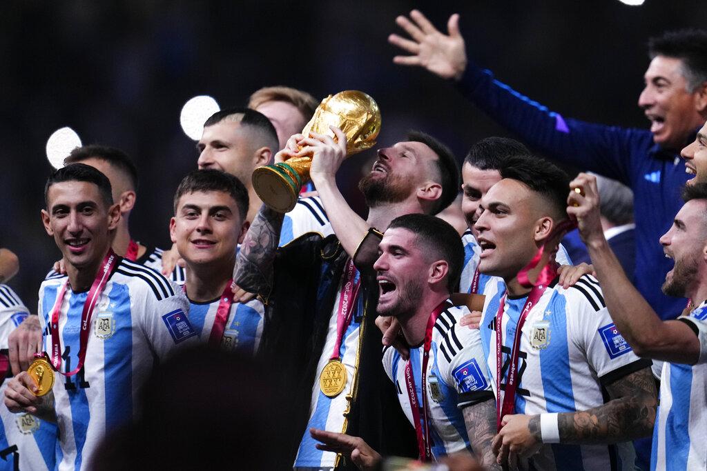 美斯被披上黑色長袍Bisht捧起世界盃。(美聯社)