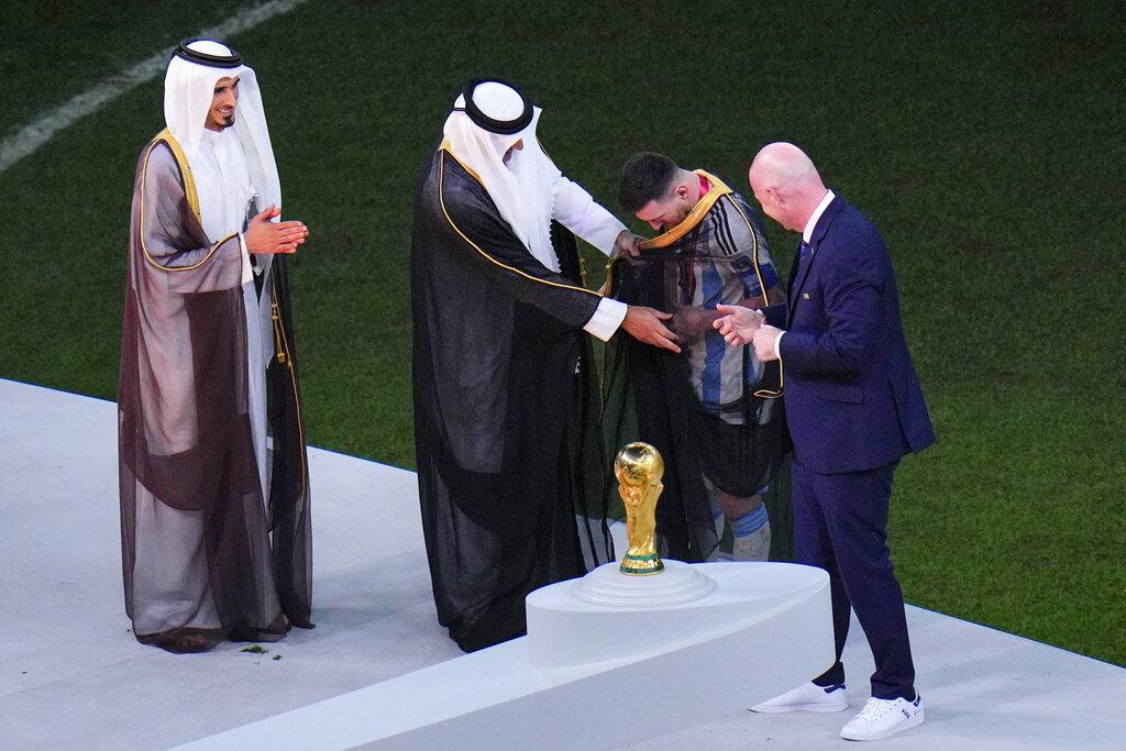 卡塔爾國王塔米姆為美斯披上黑色長袍Bisht。(美聯社)