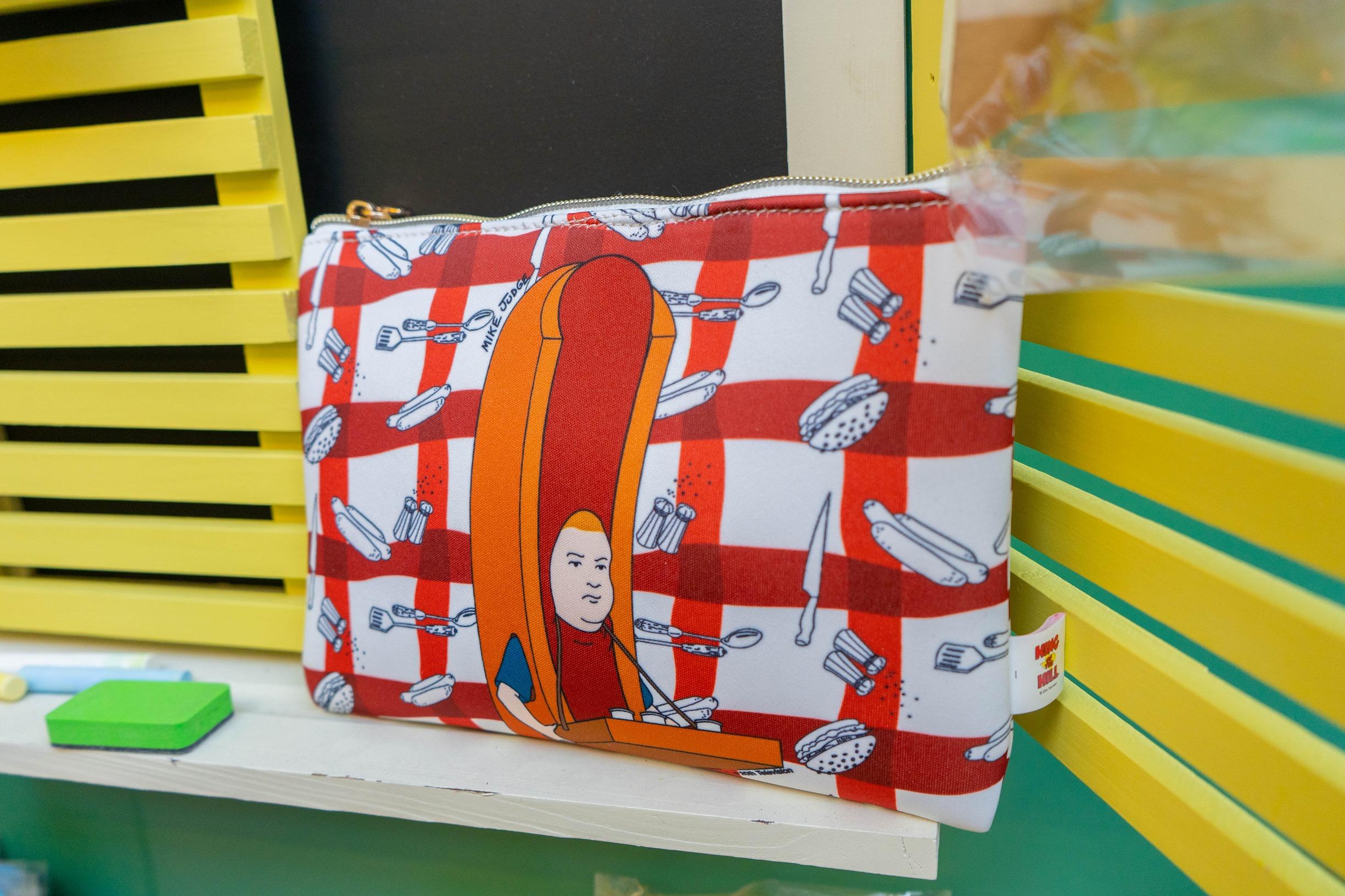 Bobby Hill 熱狗造型小物收納袋:Bobby在動畫內曾經於球場內擔任熱狗售賣員,這次收納袋用上熱狗造型的Bobby,罕見之餘又可愛。$128