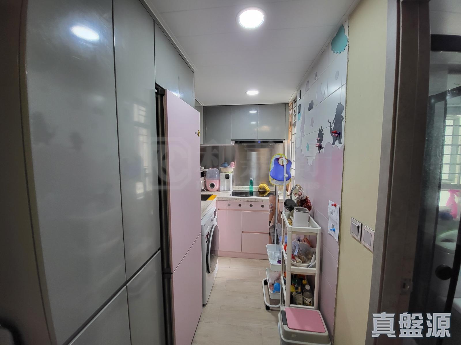 以粉紅和灰色為主調的長方形廚房,空間充裕實用。(代理提供)