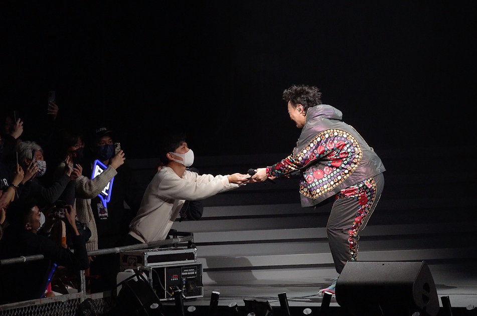 有歌迷在握手位遞上CD向Eason擺簽名。