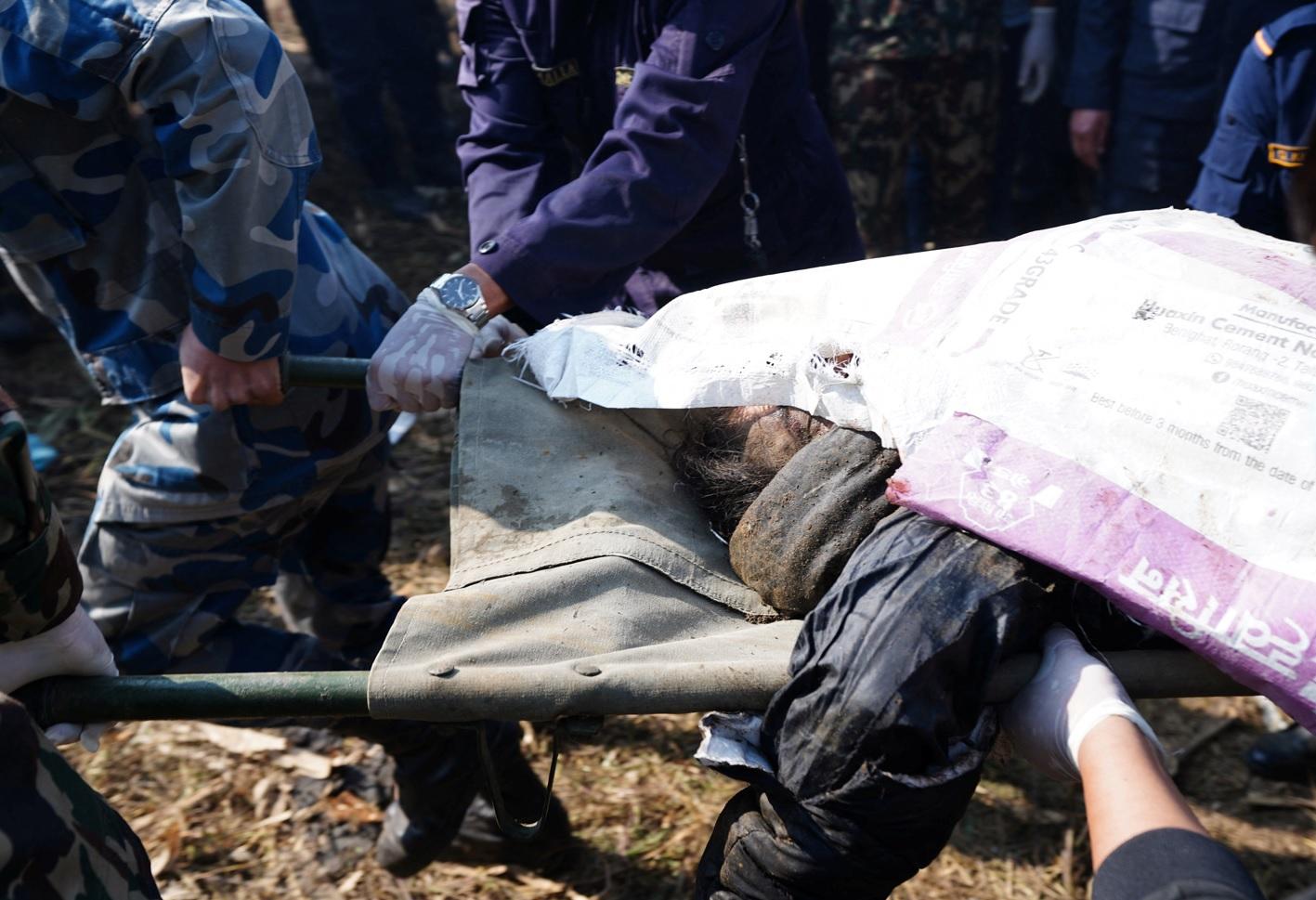 一名死者遺體被抬走。(路透社)