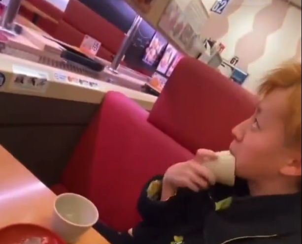 青年拿茶杯舔着杯邊。(影片截圖)