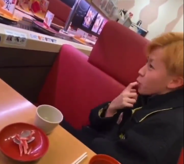 青年在手指沾上口水。(影片截圖)