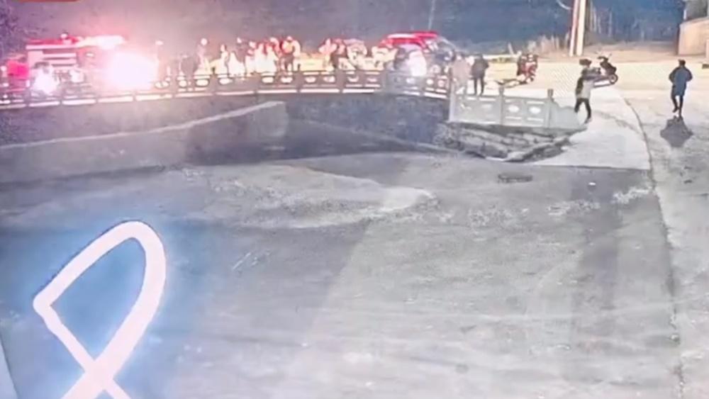 水塘裡的失事車輛僅部分露出水面,有人站上方指揮塘邊人群以大纜繩將車拉回岸邊,塘邊有大批居民圍觀。(微博)