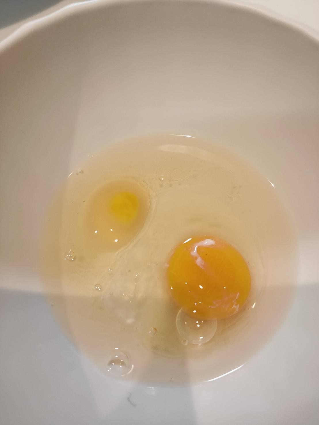 一大一小、一深一淺黃色的蛋黃在碗裡面。(Twitter)