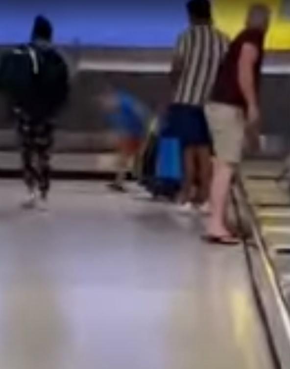 那孩子聽到自己的行為可能會招來警察後,終於乖乖地離開輸送帶。(YouTube)
