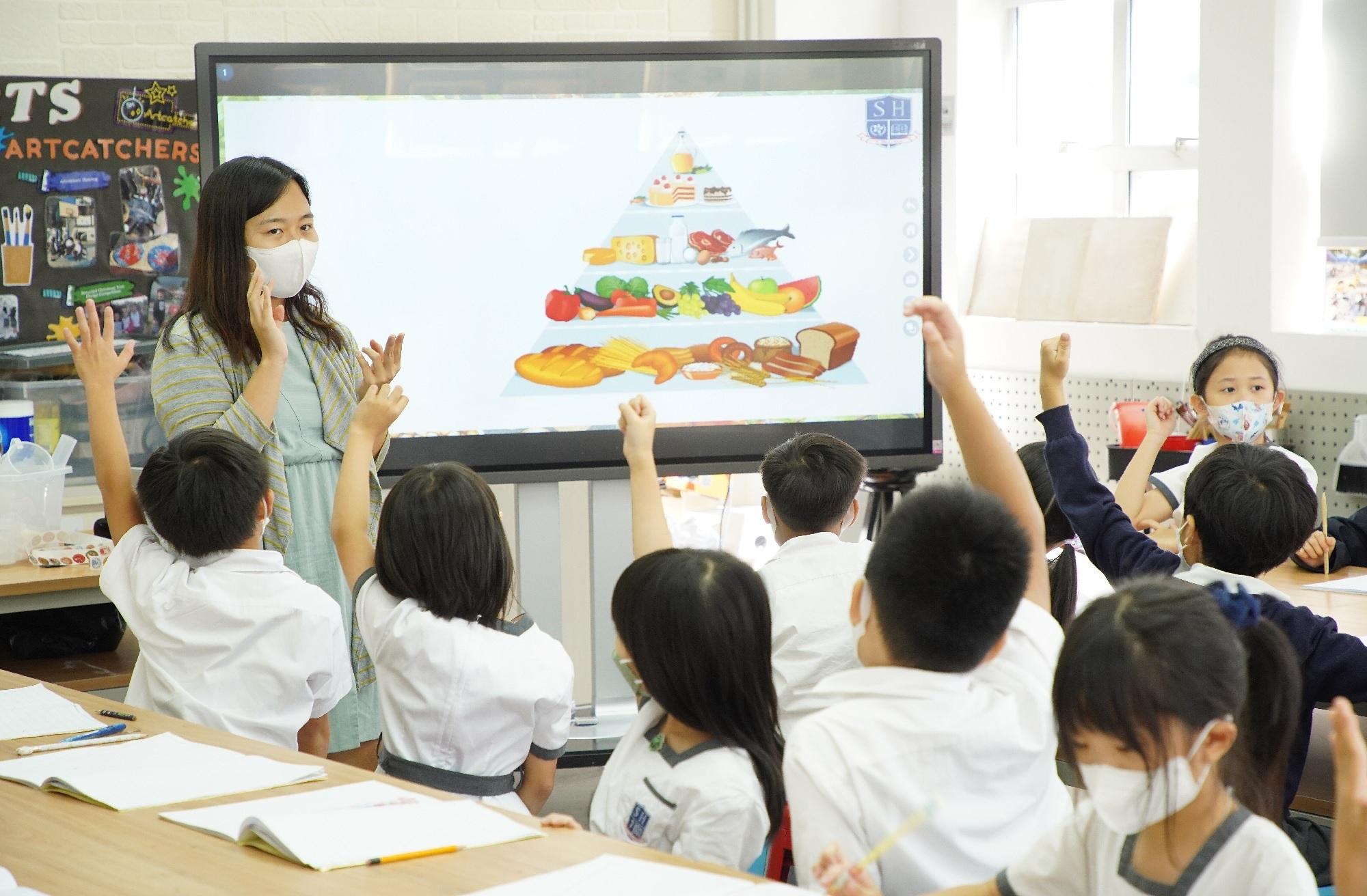 科學課時,老師講解食物金字塔及做實驗。