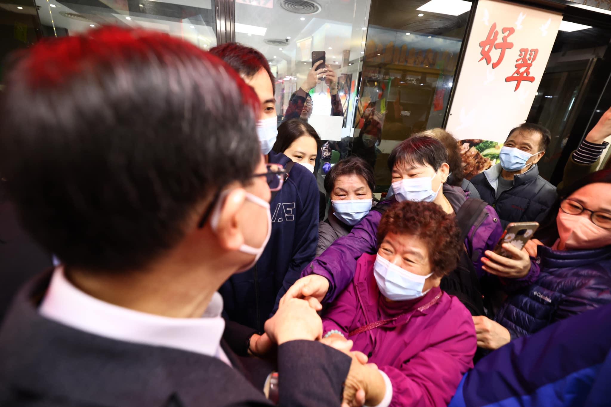 特首李家超落區與市民拜早年,並與市民握手。(李家超fb圖)