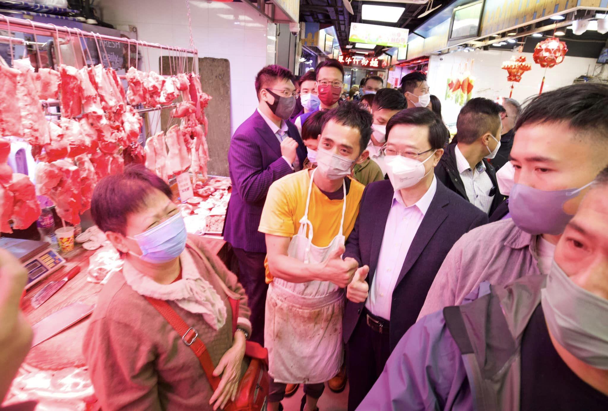 李家超到街市買揮春,並與檔販合照。(李家超fb圖)