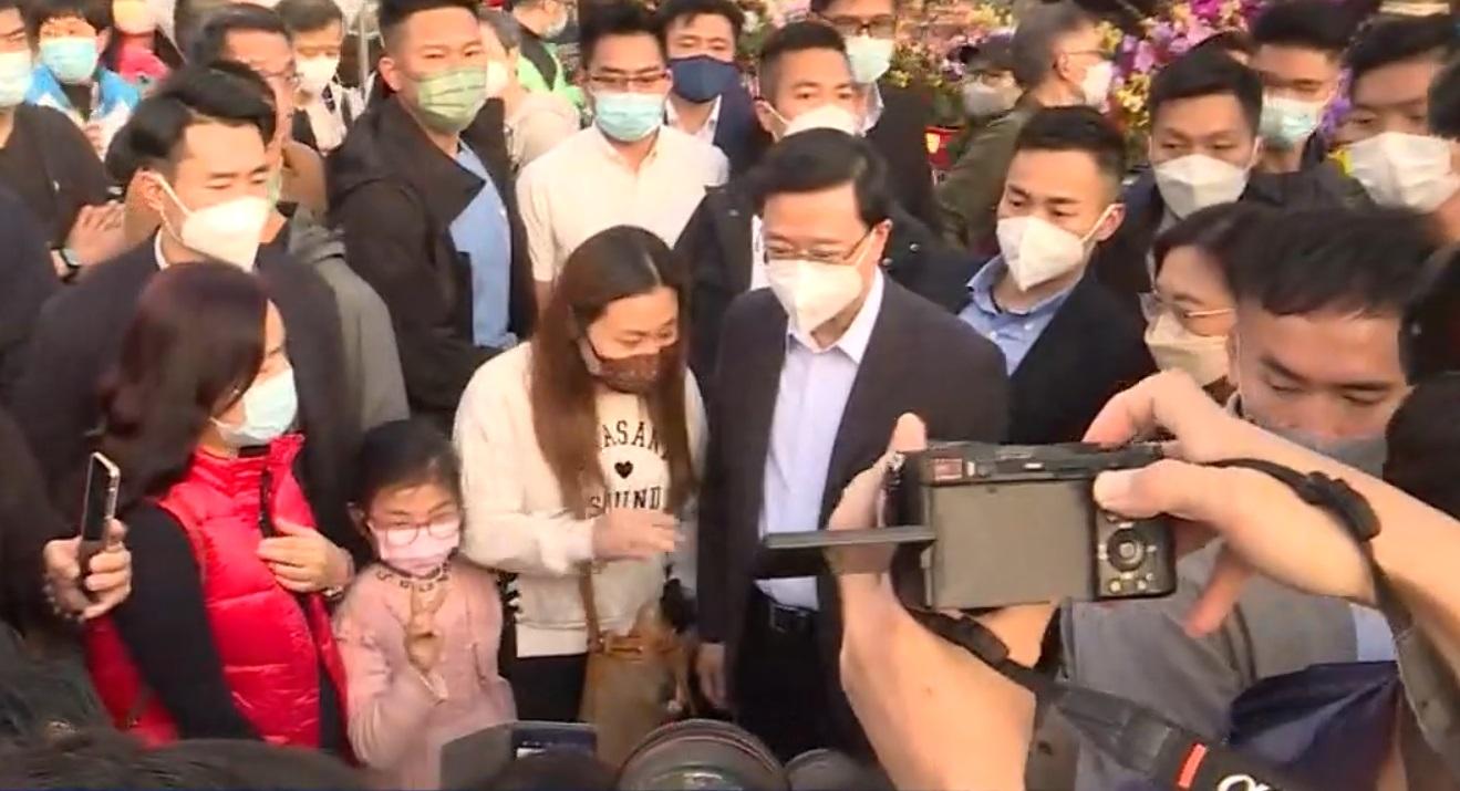 李家超下午到維園逛花市,並同市民和小朋友傾談及拍照。(直播截圖)