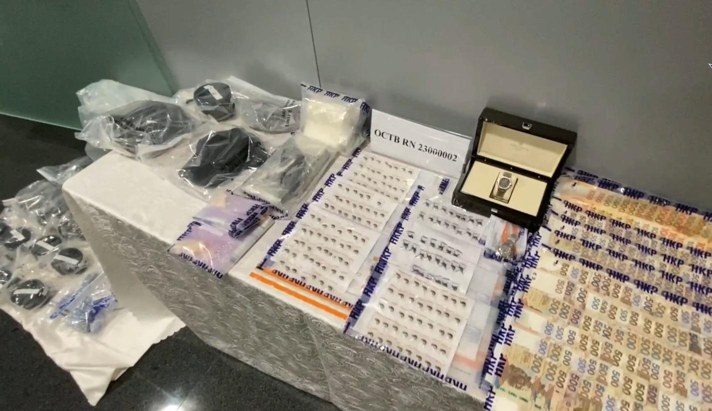 警方展示檢獲的現金及物件。(警方直播截圖)