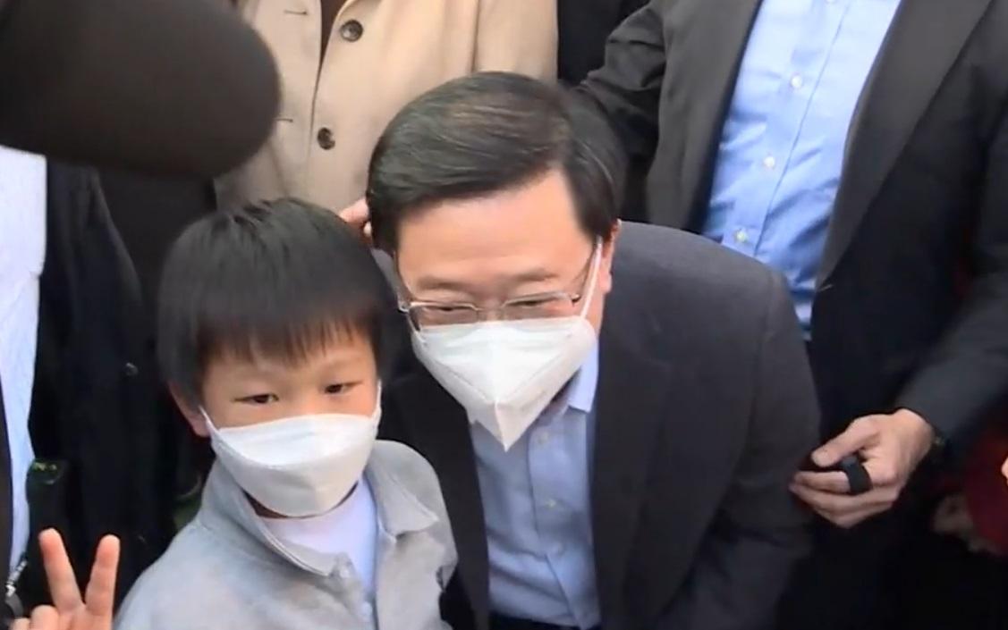 李家超下午到維園逛花市,並同市民和小朋友傾談及拍照。(直播截圖)