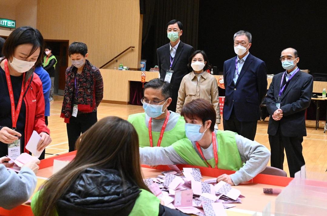 選管會主席陸啟康法官(後排右二)、民政及青年事務局局長麥美娟(後排右三)、選管會委員陸貽信資深大律師(後排右一)和石丹理教授(後排右四),今日(一月八日)在二○二三年鄉郊一般選舉村代表選舉設於將軍澳順德聯誼總會梁潔華小學的點票站,視察點票情況。