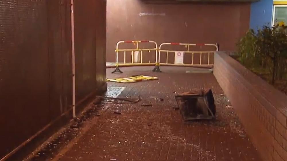 外牆冷氣機被焚毀飛墮地面,無擊中人。(電視截圖)