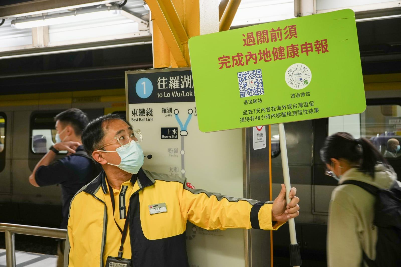 港鐵職員提醒旅客前往內地須作內地健康申報。(李睿哲攝)
