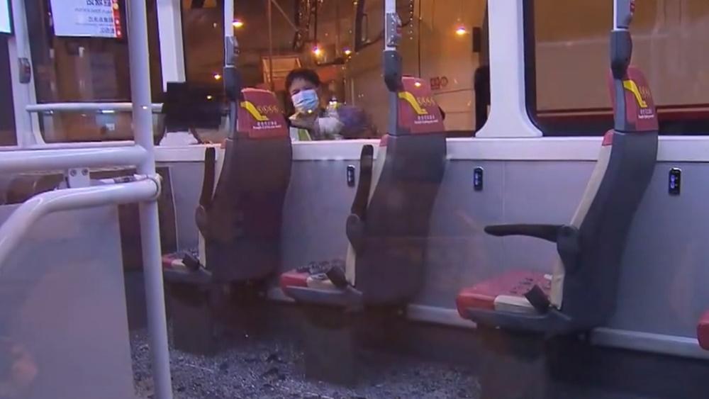 玻璃碎片散落車廂及巴士站地上,1名女乘客受傷。(電視截圖)