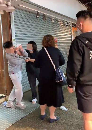 一名灰衣男上前阻止,被菜檔女職員拉扯及扯頭髮。(FB)