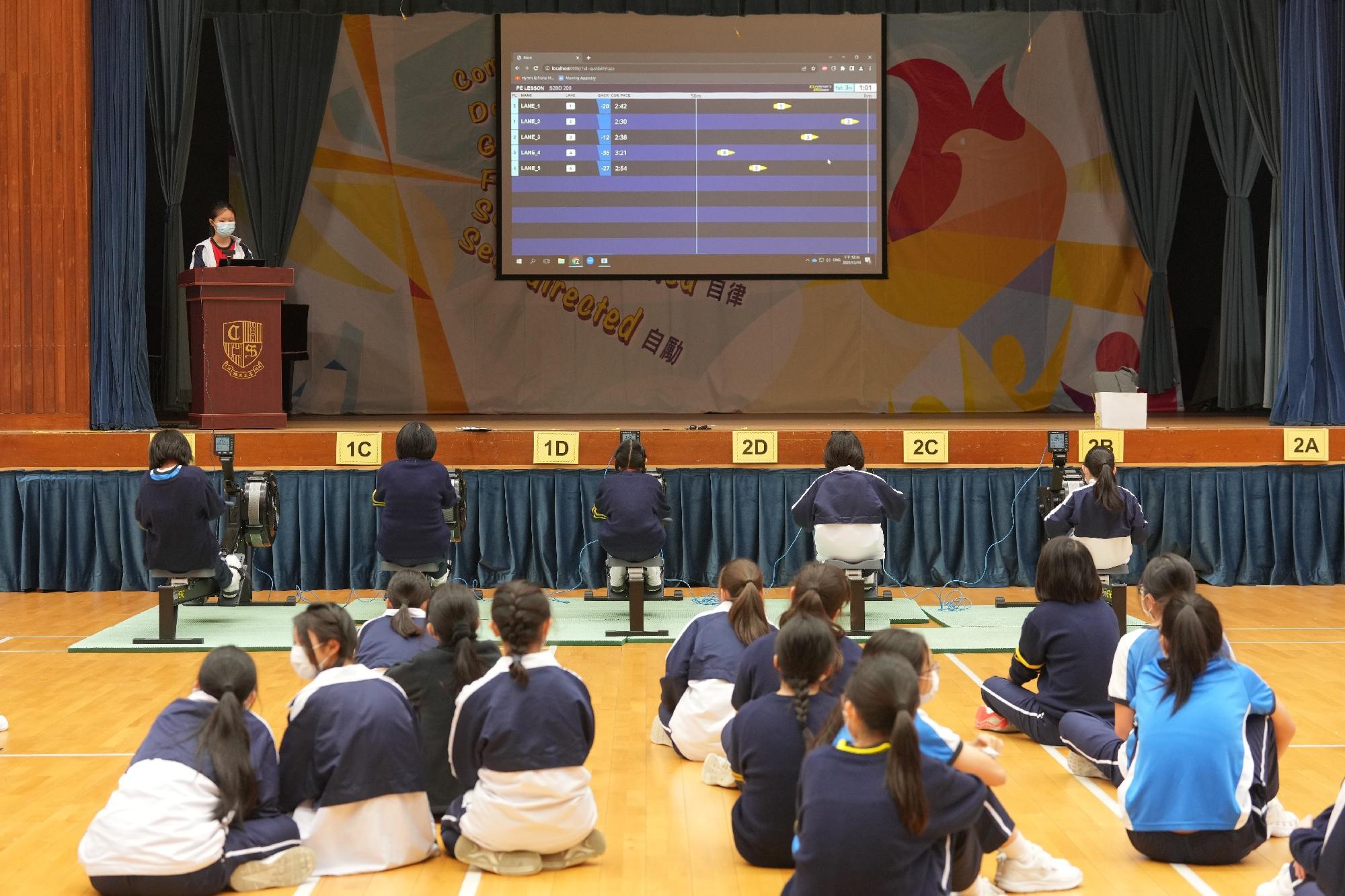 在體育課學生利用電子器材比賽划艇。