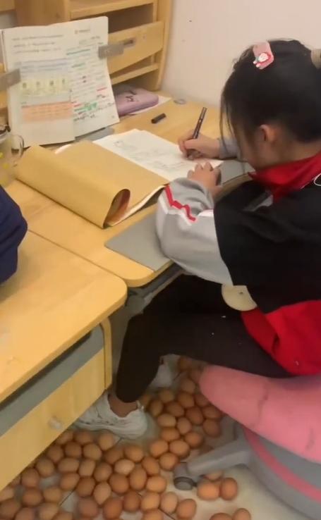 河北一位媽媽將雞蛋放在女兒腳下,女兒終於坐定定做功課。(抖音)