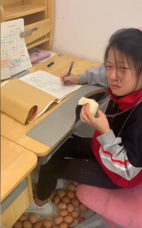 片中女兒含淚咬了一口饅頭。(抖音)