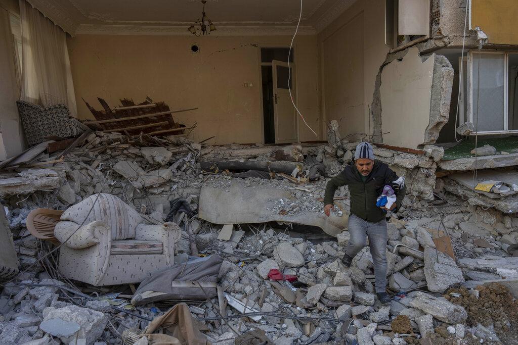 土耳其Antakya一名男子在廢墟中撿拾可用物品。(美聯社)