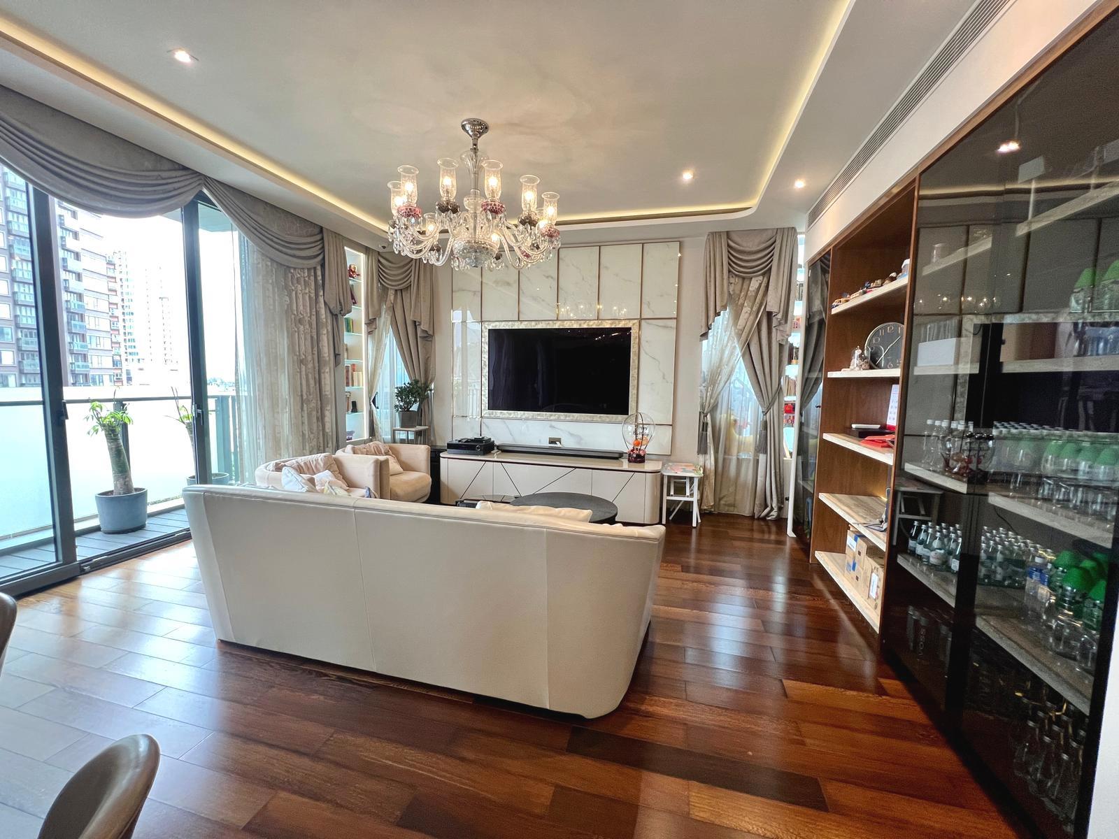 客廳裝修以米白色為主調,配以大型水晶吊燈及簡約的弧形天花線,簡單而具氣派。