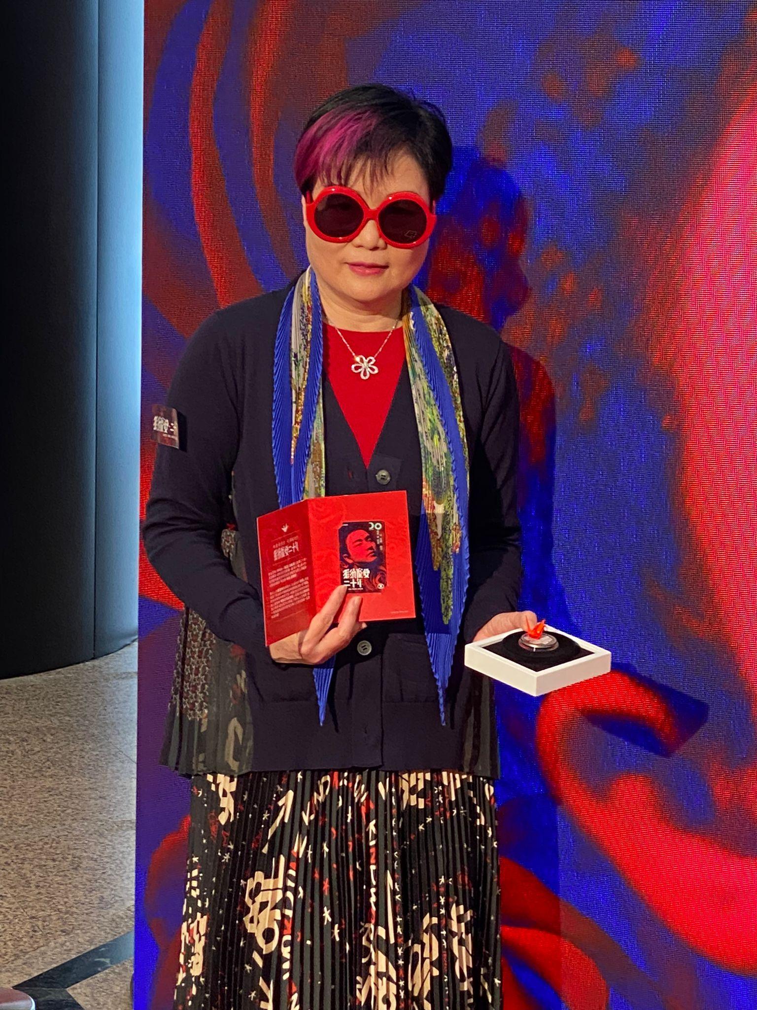 陳淑芬展示手上的港鐵紀念車票及20周年復古紀念章