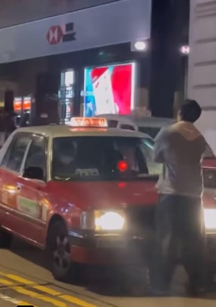 男子未肯罷休,掙脫女友人手後再雙手交疊站在的士前面。 (的士司機資訊網 Taxi@FB)
