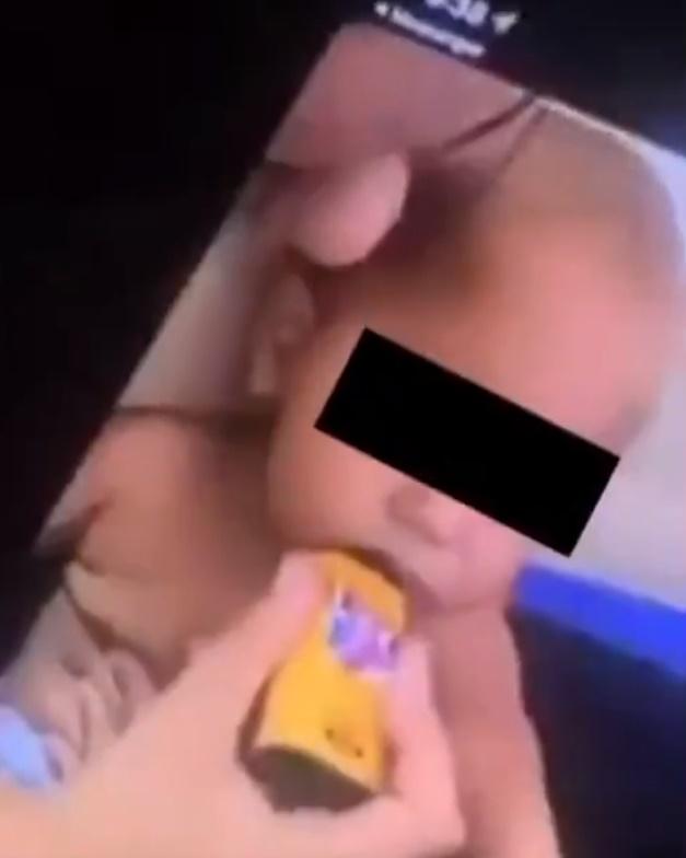 一名女子手中拿著電子煙時,笑著問男嬰「想試試看嗎」,接著便把電子煙塞入男嬰咀裡。(Twitter)