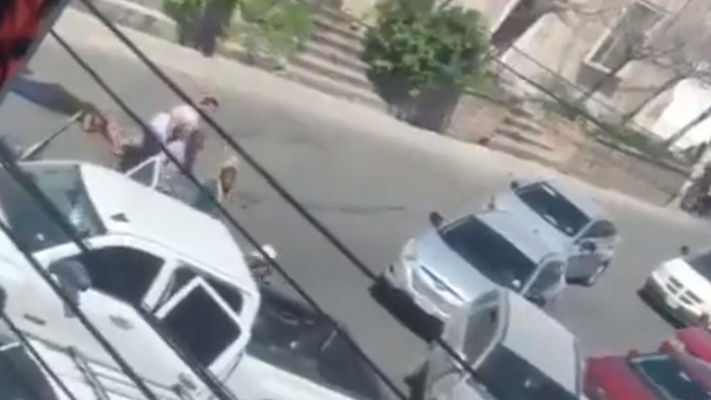 幾名全副武裝的人走出,將SUV內的人拉上一輛白色農夫車的車斗。(Twitter)