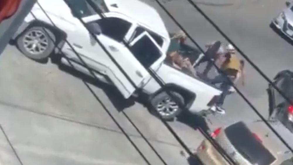 幾名全副武裝的人走出,將SUV內的人拉上一輛白色農夫車的車斗。(Twitter)