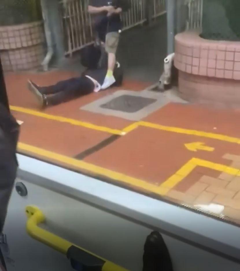 藍衫男子將巴士大叔拖落車繼續打,最終大叔躺在地上。(網片截圖)