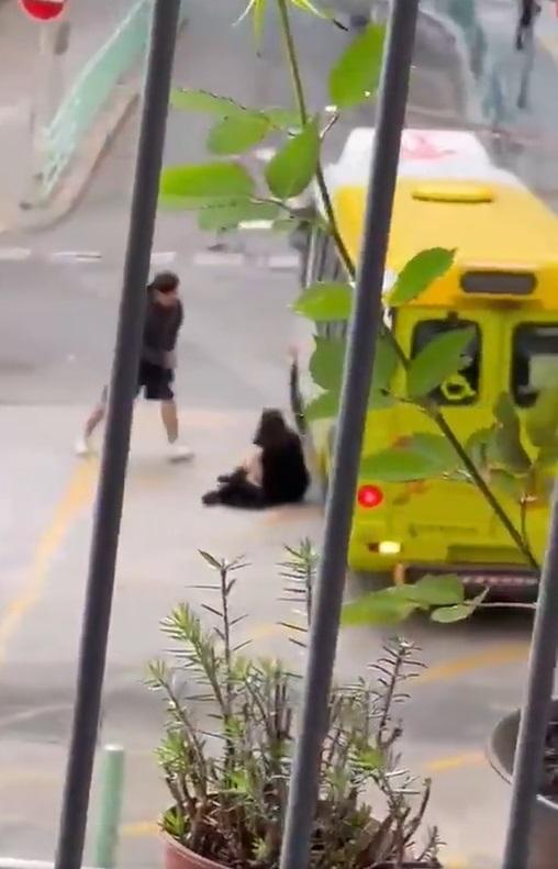 女方被推跌在地,頭撼小巴。(網片截圖)