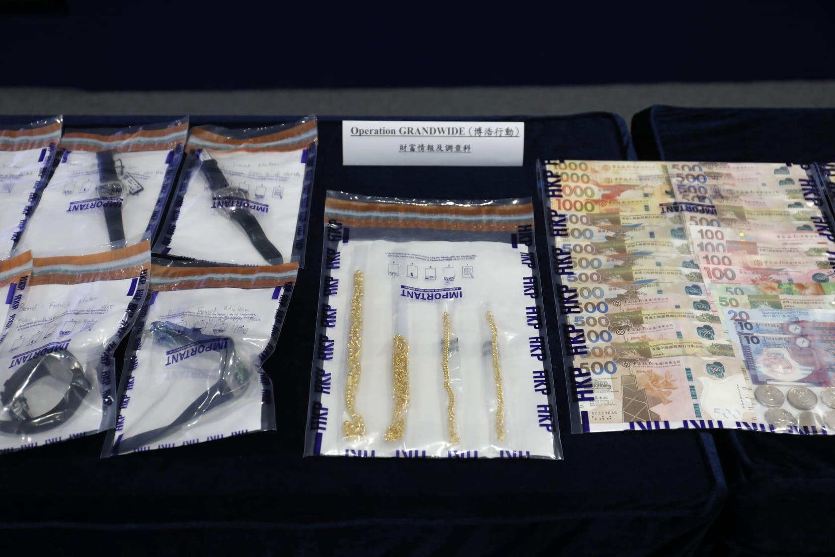 警方展示檢獲的金條、名錶及現金。(林俊源攝)