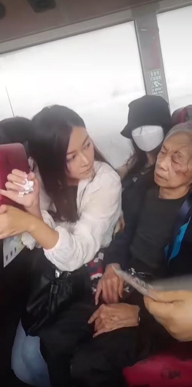 婆婆眼角疑似受傷,旁邊的女乘客手握紙巾,一臉關心。(網片截圖)