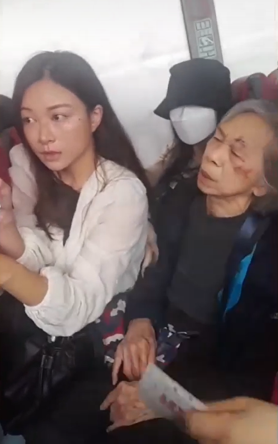 婆婆眼角疑似受傷,旁邊的女乘客手握紙巾,一臉關心。(網片截圖)