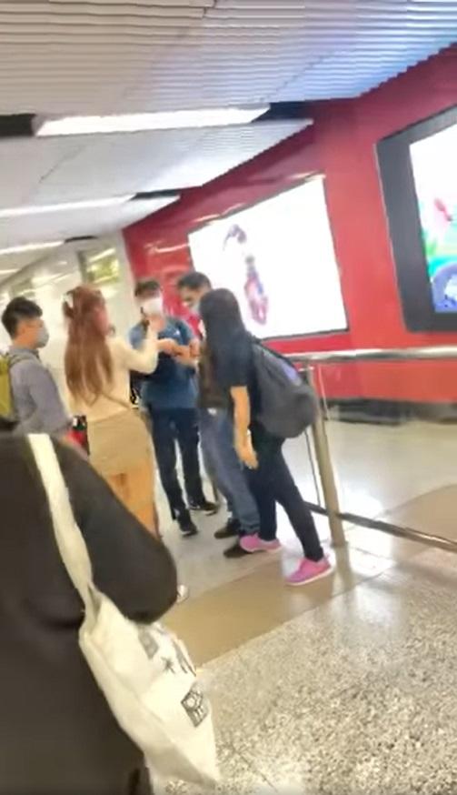 有女途人踩著眼鏡男子的腳,以防止他逃走;短裙女就吆喝他刪除圖片。