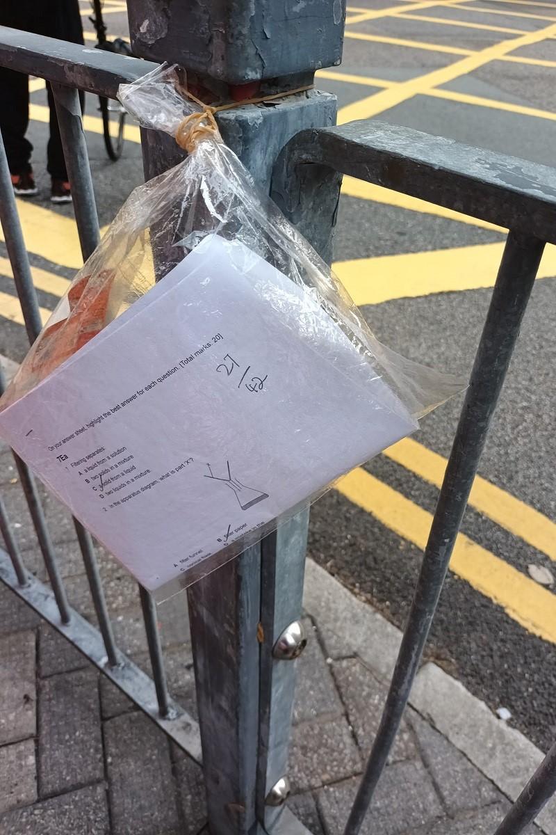 有西灣河街坊在地上拾獲一份試卷,隨即將其用袋入好綁在欄杆,等待物主自行認領。(FB群組「筲箕灣西灣河關注組」)