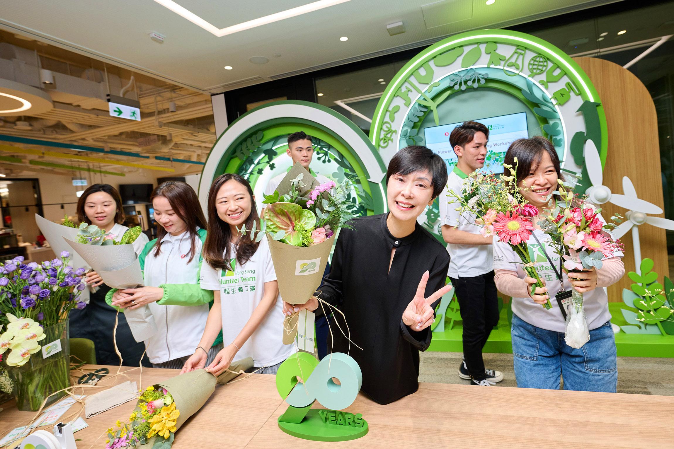 恒生銀行執行董事兼行政總裁施穎茵女士與一眾員工在花藝師指導下,將90周年慶祝酒會獲贈的花籃回收再造,重新包裝成小花束送贈予基層家庭婦女及長者,將賓客的心意傳遞至社區。