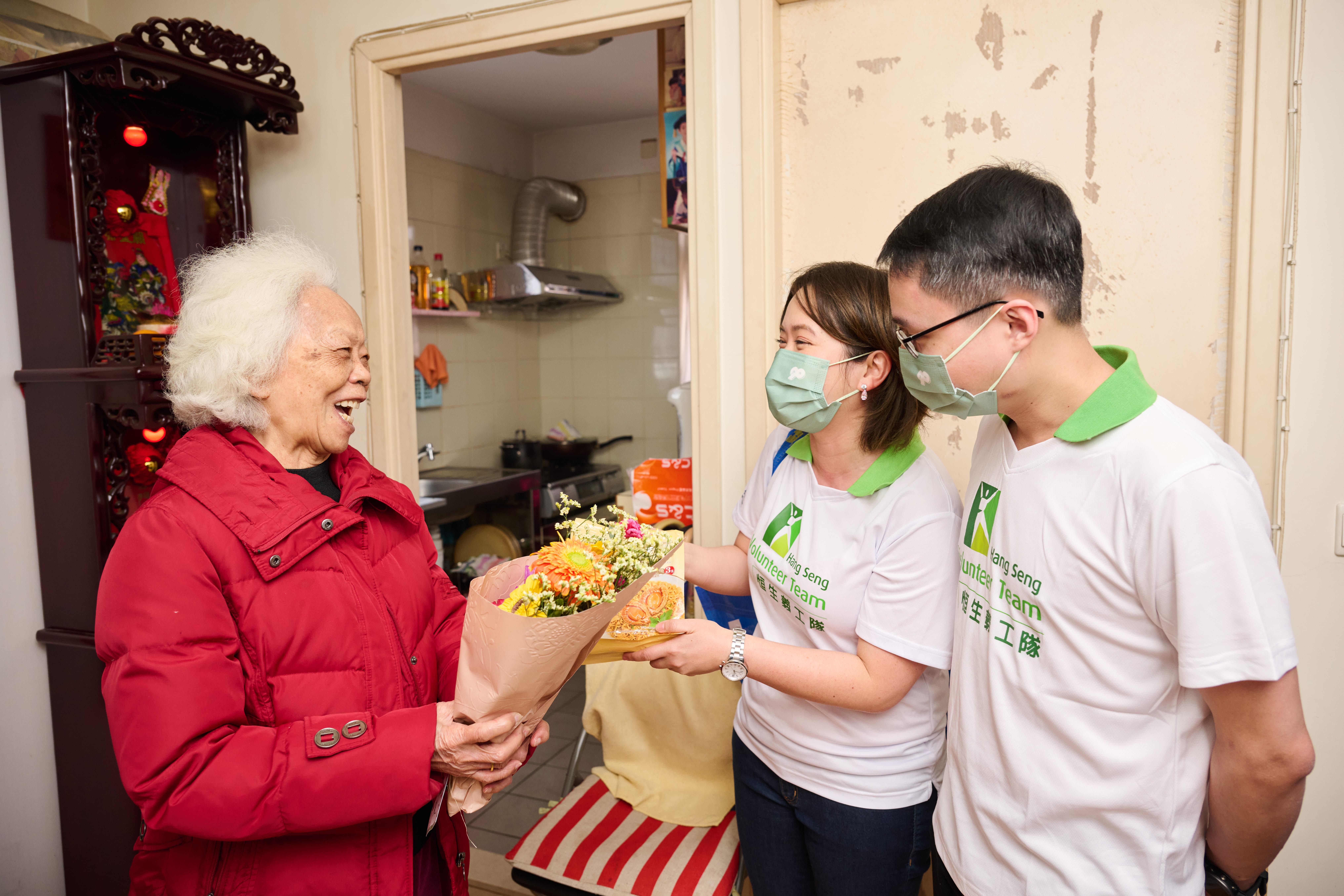 恒生義工隊聯同方樹泉綜合家居照顧服務中心社工上門派發午餐予長者,並送贈小花束與食品。
