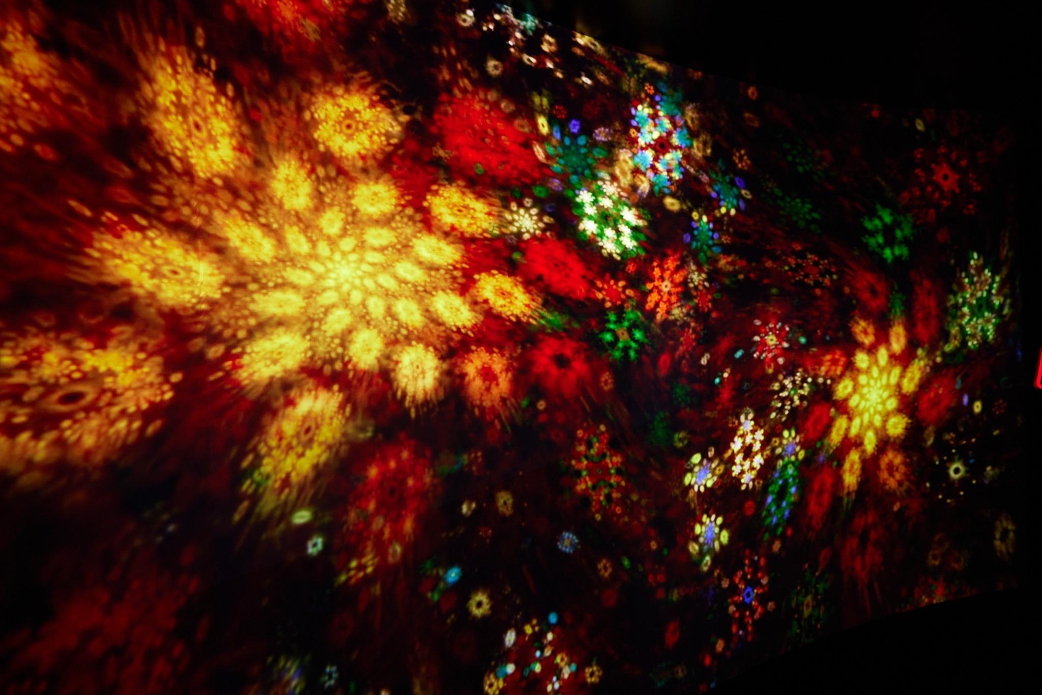 來到隧道盡頭絢爛奪目、變幻流動的光影藝術投射在巨型牆壁上。