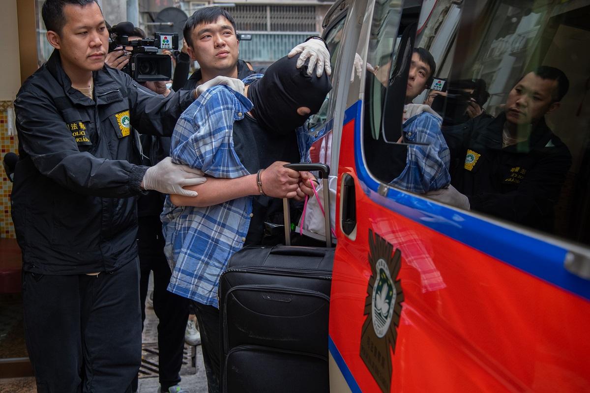 司警將一名香港籍男疑犯押返案發現場重組案情。(中通社)