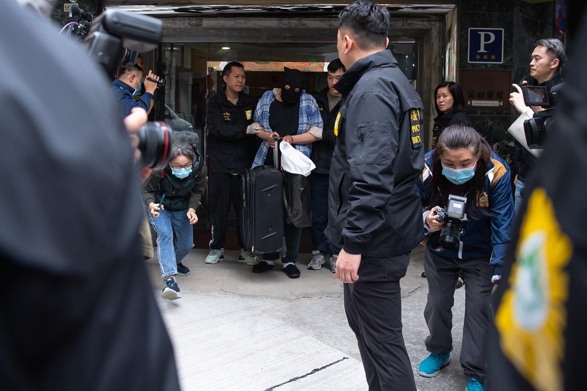 司警將一名香港籍男疑犯押返案發現場重組案情。(中通社)