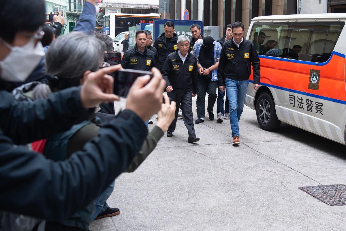 司警將一名香港籍男疑犯押返案發現場重組案情。(中通社)