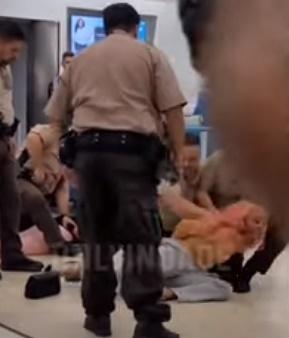 警員在機場制服2名涉事乘客。(YouTube)