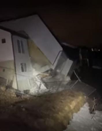 警察和消防員在擋泥土的擋土牆部分倒塌、房屋開始發出噪音後前往現場並拍下影片。(YouTube)