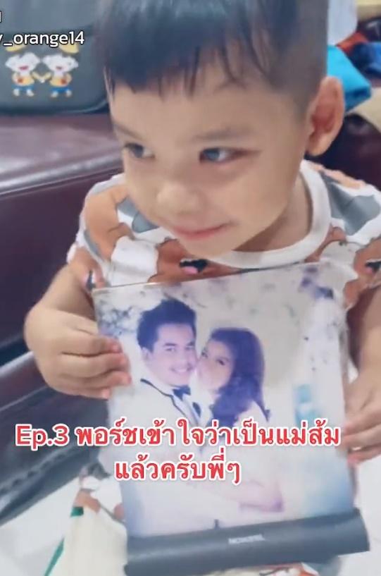 最終,在爸媽的解釋後,兒子終於面露笑容,抱著父母的婚紗照。(Twitter)